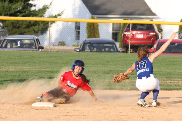 Nikos Frazier | The Vindicator.. Canfield Kaili Gross(17), slides into second as Poland's shortstop Lauren Sienkiewicz(17), catches the ball too late during the Junior League district title game at the Field of Dreams in Boardman.