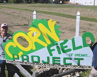 SPECIAL TO THE VINDICATOR
St. Patrick Church member and local artist Allan Orr, left, and church maintenance man Steven Inglis recently installed a new cornfield sign near the church on the south side of Youngstown. This is the second year the church has planted corn on the one acre site; a Primus variety was planted this year. An adjacent acre has over 20 garden plots tended by parishioners and neighbors of St. Patrick.