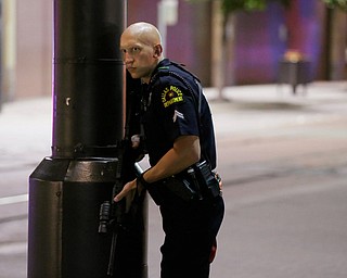 A Dallas policeman keeps watch on a street in downtown Dallas, Thursday, July 7, 2016, following reports that shots were fired during a protest over two recent fatal police shootings of black men. (LM Otero | AP Photo)