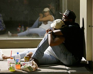 People wait to return to their cars early as police investigate the scene of Thursday's shooting, on Friday, July 8, 2016, in Dallas. Snipers opened fire on police officers in the heart of Dallas Thursday night, during protests over two recent fatal police shootings of black men. (Mark Mulligan | Houston Chronicle via AP)