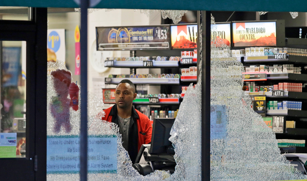 A clerk looks at broke windows shot out at a store in downtown Dallas, Friday, July 8, 2016.  Snipers opened fire on police officers in the heart of Dallas during protests over two recent fatal police shootings of black men.(LM Otero | AP Photo)