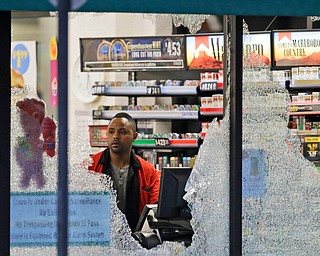 A clerk looks at broke windows shot out at a store in downtown Dallas, Friday, July 8, 2016.  Snipers opened fire on police officers in the heart of Dallas during protests over two recent fatal police shootings of black men.(LM Otero | AP Photo)