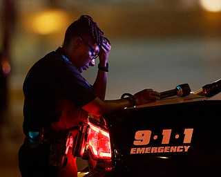 A Dallas police officer, who did not want to be identified, takes a moment as she guards an intersection in the early morning after a shooting in downtown Dallas, Friday, July 8, 2016. At least two snipers opened fire on police officers during protests in Dallas on Thursday night; some of the officers were killed, police said. (LM Otero | AP Photo)
