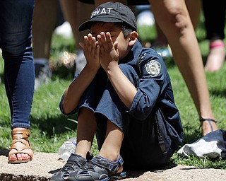 A young boy wears a police uniform as he takes part in a prayer vigil at Thanksgiving Square, Friday, July 8, 2016, in Dallas. Five police officers are dead and several injured following a shooting during what began as a peaceful protest in the city the night before. (Eric Gay | AP Photo)