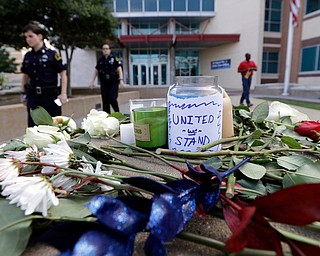 Flowers, candles and notes are left in front of the Dallas Police Station as part of a makeshift memorial, Friday, July 8, 2016, in Dallas. Five police officers are dead and several injured following a shooting during what began as a peaceful protest in the city the night before. (Eric Gay | AP Photo)
