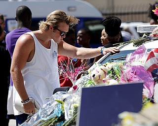 A man pauses over a make-shift memorial at the Dallas police headquarters, Friday, July 8, 2016, in Dallas. Five police officers are dead and several injured following a shooting in downtown Dallas Thursday night. (Eric Gay | AP Photo)