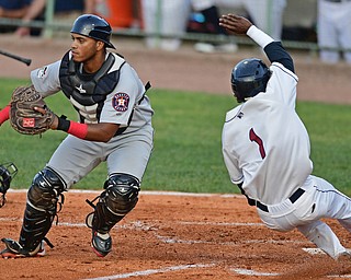 NILES, OHIO - JULY 11, 2016: Gabriel Majia #1 of the Scrappers slides across home plate to score a run while catcher Kevin Martir #32 of the ValleyCats waits to play the base, after a RBI single by Andrew Calica #26 in the fourth inning of Monday nights game at Eastwood Field. DAVID DERMER | THE VINDICATOR