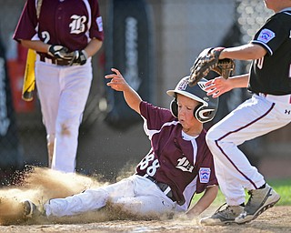 BOARD MAN, OHIO - JULY 15, 2016: Caleb Satterfield(22) of Boardman slides into home plate to score a run after a wild pitch from Benjamin Herrmann(23) of Canfield in the second inning of Friday evenings District 2 9/10 year old Little League Championship game at the Field of Dreams. Boardman would go on to win 18-5. DAVID DERMER | THE VINDICATOR