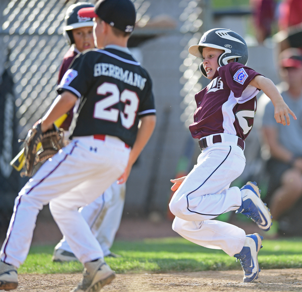 BOARD MAN, OHIO - JULY 15, 2016: Caleb Satterfield(22) of Boardman slides into home plate to score a run after a wild pitch from Benjamin Herrmann(23) of Canfield in the second inning of Friday evenings District 2 9/10 year old Little League Championship game at the Field of Dreams. Boardman would go on to win 18-5. DAVID DERMER | THE VINDICATOR