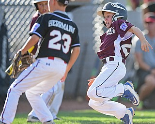 BOARD MAN, OHIO - JULY 15, 2016: Caleb Satterfield(22) of Boardman slides into home plate to score a run after a wild pitch from Benjamin Herrmann(23) of Canfield in the second inning of Friday evenings District 2 9/10 year old Little League Championship game at the Field of Dreams. Boardman would go on to win 18-5. DAVID DERMER | THE VINDICATOR