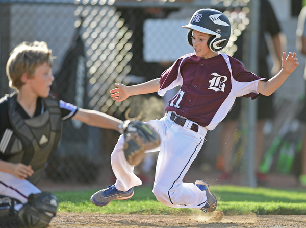 BOARD MAN, OHIO - JULY 15, 2016: Evan Sweder(11) of Boardman slides into home plate to score a run while beating the tag from catcher Nicky Beistel(41) of Canfield in the second inning of Friday evenings District 2 9/10 year old Little League Championship game at the Field of Dreams. Boardman would go on to win 18-5. DAVID DERMER | THE VINDICATOR