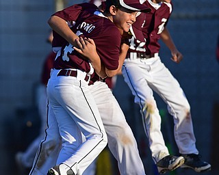 BOARD MAN, OHIO - JULY 15, 2016: Relief pitcher Charlie Young(4) of Boardman is hugged by teammate Gavin Hyde(2), while Matt Kay(42) leaps behind them after the conclusion of Friday evenings District 2 9/10 year old Little League Championship game at the Field of Dreams. Boardman would go on to win 18-5. DAVID DERMER | THE VINDICATOR