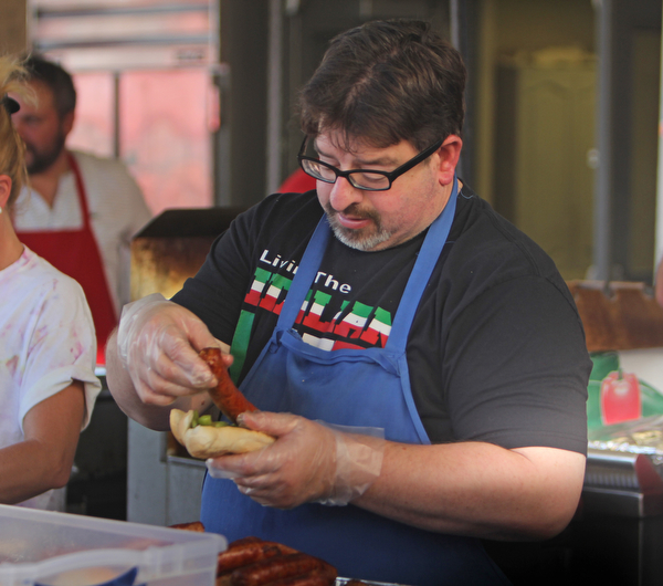 Joe Rossi III of Niles makes a sausage sandwhich during the Our Lady of Mount Carmel Festival in Niles on Sunday evening.  Dustin Livesay  |  The Vindicator  7/17/16  Niles.
