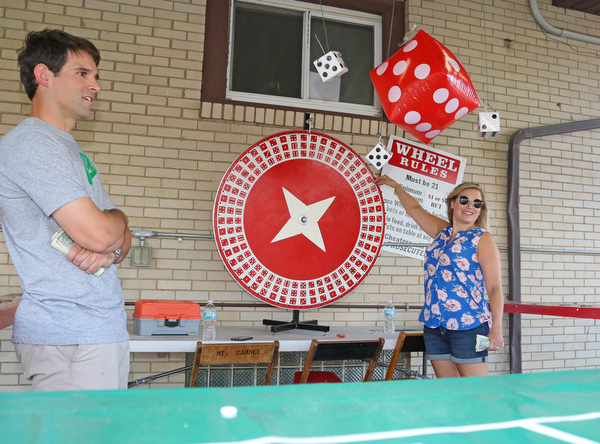 Nick Setting (left) and his wife Annie Setting of Howland work on the dice wheel game during the Our Lady of Mount Carmel Festival in Niles on Sunday evening.  Dustin Livesay  |  The Vindicator  7/17/16  Niles.