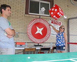Nick Setting (left) and his wife Annie Setting of Howland work on the dice wheel game during the Our Lady of Mount Carmel Festival in Niles on Sunday evening.  Dustin Livesay  |  The Vindicator  7/17/16  Niles.