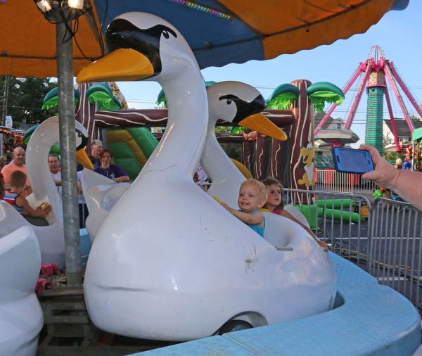 Preston Bell (2) of Warren rides on the swans during the Our Lady of Mount Carmel Festival in Niles on Sunday evening.  Dustin Livesay  |  The Vindicator  7/17/16  Niles.