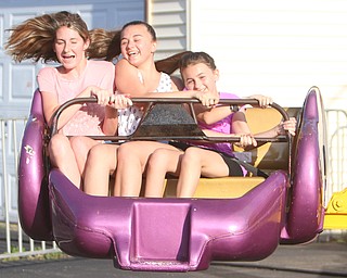 Alissa Reichard (16) of Niles, Emily Kellogg (13), and Abby Kellogg (10) of Hinckley, Ohio ride together on the "sizzler" during the Our Lady of Mount Carmel Festival in Niles on Sunday evening.  Dustin Livesay  |  The Vindicator  7/17/16  Niles.