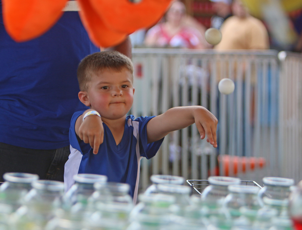 Rayden Iamurri (4) of Poland throws ping pong balls into fishbowls to win a prize during the Our Lady of Mount Carmel Festival in Niles on Sunday evening.  Dustin Livesay  |  The Vindicator  7/17/16  Niles.