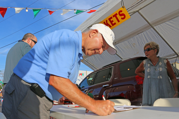 Louis Yacucci of North Jackson fills out a raffle ticket to win one of three grand prizes during the Our Lady of Mount Carmel Festival in Niles on Sunday evening.  Dustin Livesay  |  The Vindicator  7/17/16  Niles.