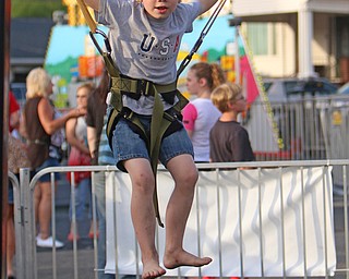 Andrew Campbell (6) of McDonald bounces while connected to bungie cords during the Our Lady of Mount Carmel Festival in Niles on Sunday evening.  Dustin Livesay  |  The Vindicator  7/17/16  Niles.