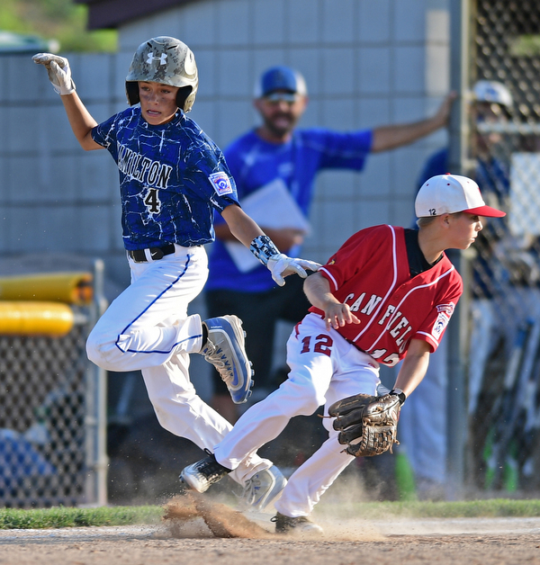 BOARDMAN, OHIO - JULY 19, 2016: Landyn Vidourek #4 of Hamilton West is safe at first base after Ryan Petro #12 of Canfield was unable to field the throw allowing Vidourek to reach second base in the second inning of their game Tuesday night at the Fields of Dreams. Hamilton West won 2-0. DAVID DERMER | THE VINDICATOR