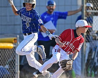 BOARDMAN, OHIO - JULY 19, 2016: Landyn Vidourek #4 of Hamilton West is safe at first base after Ryan Petro #12 of Canfield was unable to field the throw allowing Vidourek to reach second base in the second inning of their game Tuesday night at the Fields of Dreams. Hamilton West won 2-0. DAVID DERMER | THE VINDICATOR