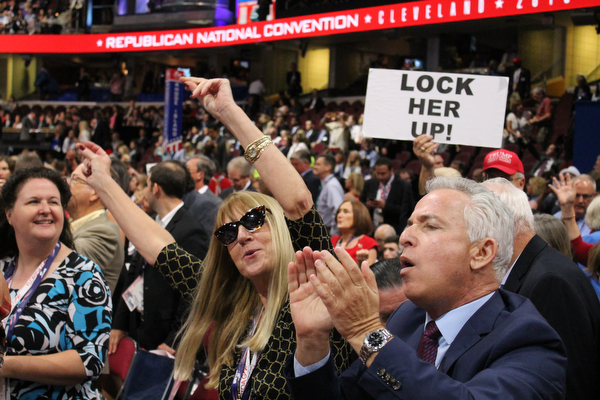 Other state delegates dancing on the floor, with a sign aimed at Hillary Clinton in the background..
