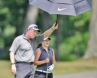 Jeff Lange | The Vindicator  FRI, JUL 22, 2016 - Ken Cerimele of Canfield (left) holds an umbrella over his daughter Gillian as they survey the No. 8 fairway during Friday's Greatest Golfer of the Valley Junior finals held at Avalon at Squaw Creek.