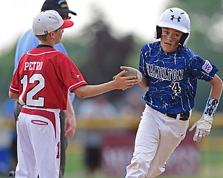 BOARDMAN, OHIO - JULY 24, 2016: Landyn Vidourek #4 of Hamilton trots around the bases after hitting a home run while being congratulated by short stop Ryan Petro #12 of Canfield in the sixth inning of Sunday afternoons Little League State Championship Game at the Fields of Dreams. Hamilton won 11-0. DAVID DERMER | THE VINDICATOR
