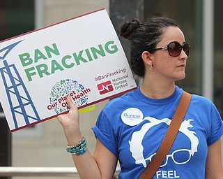Nikos Frazier | The Vindicator..Cecilia holds a "Ban Fracking" sign while walking with Sen. Bernie Sanders supporters down Broad St. on the first day of the Democratic National Convention in Philadelphia.