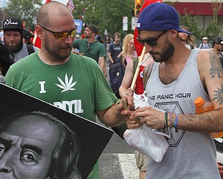 Nikos Frazier | The Vindicator..Two protestors holds marijuana joints while marching with Sen.Bernie Sanders supporters on the first day of the Democratic National Convention in Philadelphia.