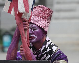Nikos Frazier | The Vindicator..A man painted in purple sits in silence in a courtyard of Philadelphia's City Hall on the first day of the Democratic National Convention.
