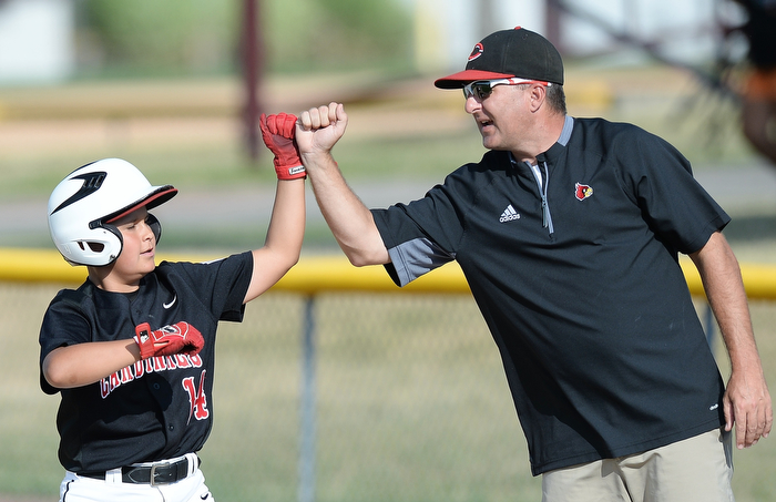 Jeff Lange | The Vindicator  MON, JUL 25, 2016 - Canfield's Ben Slanker (14) is congratulated by first base coach Dan Stricko after hitting a single in the top of the fourth inning of Monday's game against Washington Court House in Boardman.