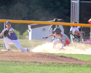 Nikos Frazier | The Vindicator..East Holmes' Brett Miller(3) slides into third in the first inning during the Junior Little League State Championship game at the Fields of Dreams in Boardman.