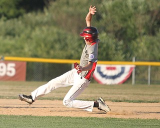 Nikos Frazier | The Vindicator..An East Holmes runner slides into third in the third inning of the Junior Little League State Championship game at the Fields of Dreams in Boardman.