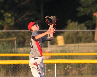 Nikos Frazier | The Vindicator..East Holmes' Korrie Hostetler(13) opens his mitt in the outfield in the fourth inning during the Junior Little League State Championship game at the Fields of Dreams in Boardman.