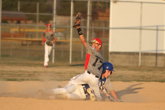Nikos Frazier | The Vindicator..East Holmes' Patt Miller(17) holds his mitt in the air afterPoland's Josh Blask0(7) slides into second during the Junior Little League State Championship game at the Fields of Dreams in Boardman.