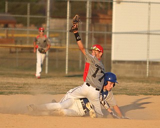 Nikos Frazier | The Vindicator..East Holmes' Patt Miller(17) holds his mitt in the air afterPoland's Josh Blask0(7) slides into second during the Junior Little League State Championship game at the Fields of Dreams in Boardman.