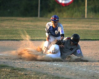 Nikos Frazier | The Vindicator..Poland's Jake Bacon(8) tags an East Holmes' runner as he slides into third with an empty glove in the fifth inning during the Junior Little League State Championship game at the Fields of Dreams in Boardman.