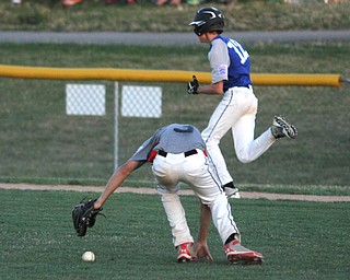 Nikos Frazier | The Vindicator..East Holmes' pitcher Brett Miller(3) fumbles with the ball as a Poland runner closes in on first during the Junior Little League State Championship game at the Fields of Dreams in Boardman.