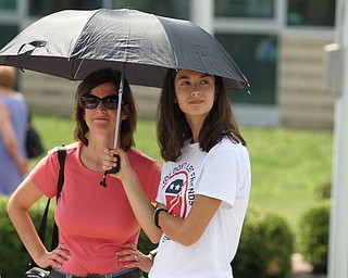 Nikos Frazier | The Vindicator..Dawn Crawford(right), of Salem and her daughter Abbey, 14, shade themselves with an umbrella outside of East High School before Democratic Presidential candidate Hillary Clinton spoke on Saturday night.