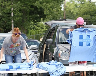 Nikos Frazier | The Vindicator..Kevin Joness(right) and Stefanie Miranda of Arkansas lay out their merchandise outside of East High School before Democratic Presidential candidate Hillary Clinton spoke on Saturday night. Joness and Miranda have been following Clinton for the past 11 months.