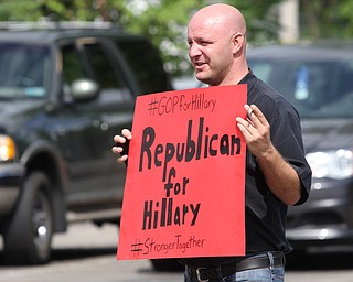 Nikos Frazier | The Vindicator..Sean Cornelius of Austintown holds a "Republican for Hillary" sign outside of of East High School before Democratic Presidential candidate Hillary Clinton spoke on Saturday night. Cornelius was later not allowed to carry the sign inside the event.