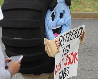 Nikos Frazier | The Vindicator..A person in a Tire suit holds a "Retread Ted lost 350k jobs" sign outside of East High School before Democratic Presidential candidate Hillary Clinton spoke on Saturday night.