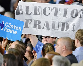 Jeff Lange | The Vindicator  SAT, JUL 31, 2016 - A protestor raises a banner during Saturday's Hillary campaign rally at East High School. Moments later he was escorted by police.