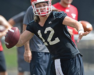 YOUNGSTOWN, OHIO - AUGUST 5, 2016: Quarterback Ricky Davis #12 of YSU looks down field while rolling out of the pocket to avoid the pass rush during a 11 on 11 session of practice Friday afternoon at Stambaugh Stadium. DAVID DERMER | THE VINDICATOR