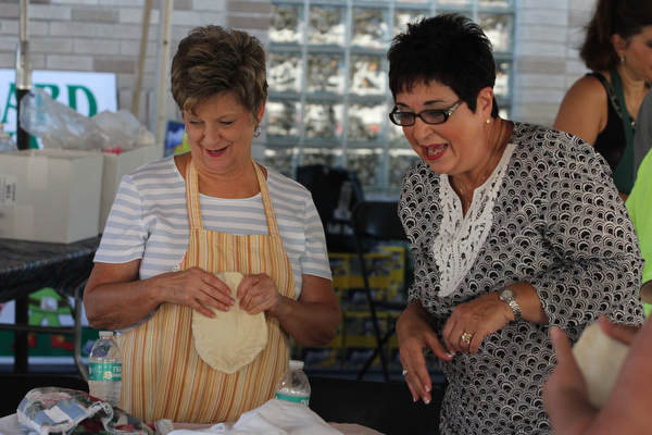 Nikos Frazier | The Vindicator..Marianne Modarelli(right) and Jean Hafely form pizza-fritte at the St. Patrick Parish Festival in Hubbard.