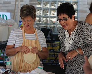 Nikos Frazier | The Vindicator..Marianne Modarelli(right) and Jean Hafely form pizza-fritte at the St. Patrick Parish Festival in Hubbard.