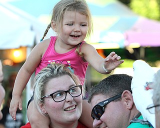 Nikos Frazier | The Vindicator..Gracie Marsh(top), 3, reaches out towards Ouija while on her sister, Rachel Mistretta's shoulders at the St. Patrick Parish Festival in Hubbard.
