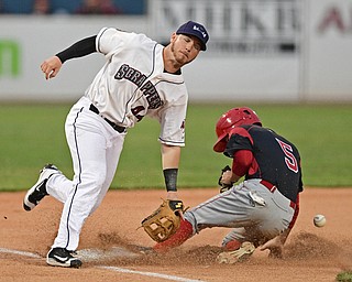 NILES, OHIO - AUGUST 10, 2016: Third baseman Gavin Collins unsuccessfully reaches for the baseball while base runner Aaron Knapp #5 of the Muckdogs steals third base, he would score on the throwing error, in the first inning of Wednesday nights game at Eastwood Field. DAVID DERMER | THE VINDICATOR